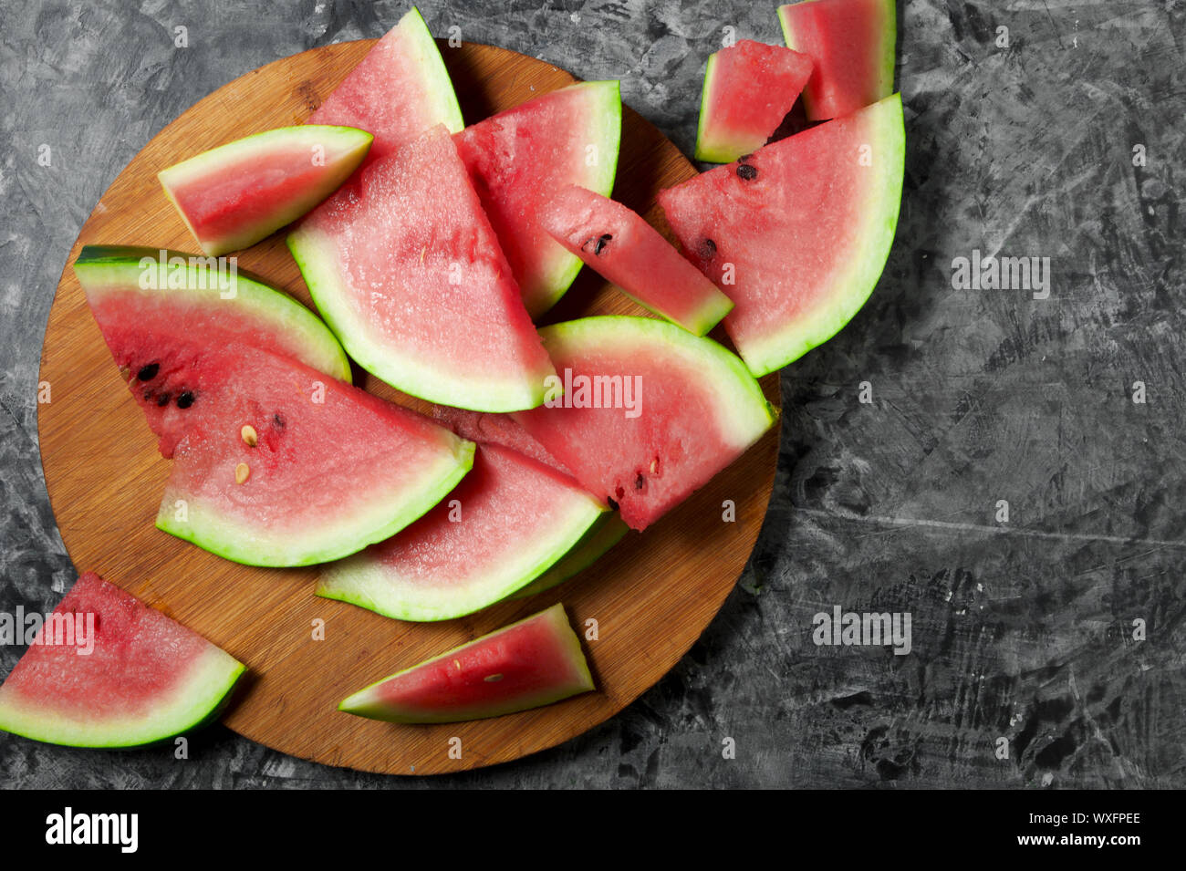 Pieces of watermelon. Sliced juicy watermelon on a gray concrete surface. View from above. Copy space. Stock Photo