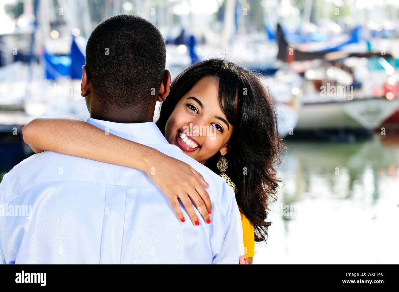 Beautiful young woman hugging boyfriend standing at harbor Stock Photo ...
