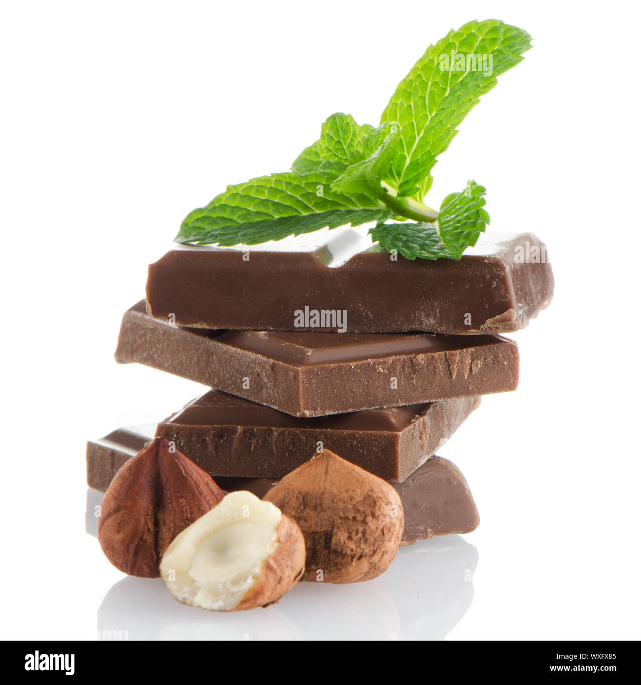 Chocolate parts and cinnamon sticks isolated on white background Stock