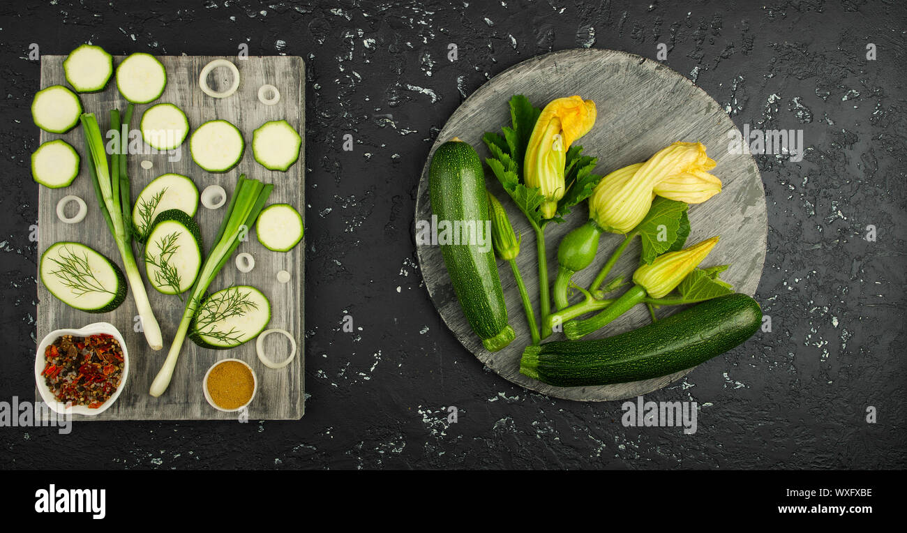 Fresh green zucchini on a dark table. The view from the top. Copy space. Stock Photo