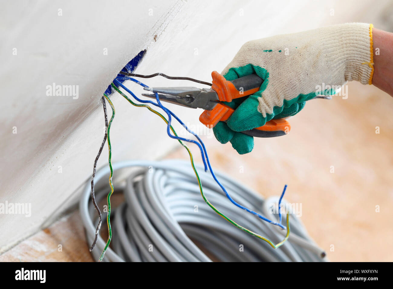 worker puts the wires in the wall Stock Photo Alamy