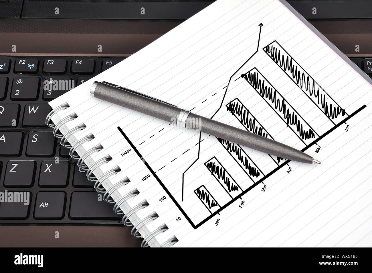 drawing chart in notebook and laptop Stock Photo - Alamy