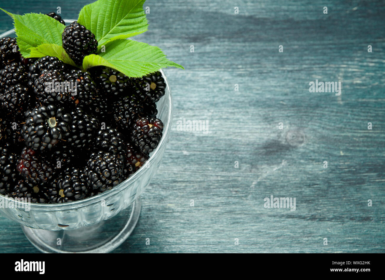 Fresh blackberry. Juicy blackberry in a bowl on a wooden table. View from above. Copy space. Harvest concept Stock Photo