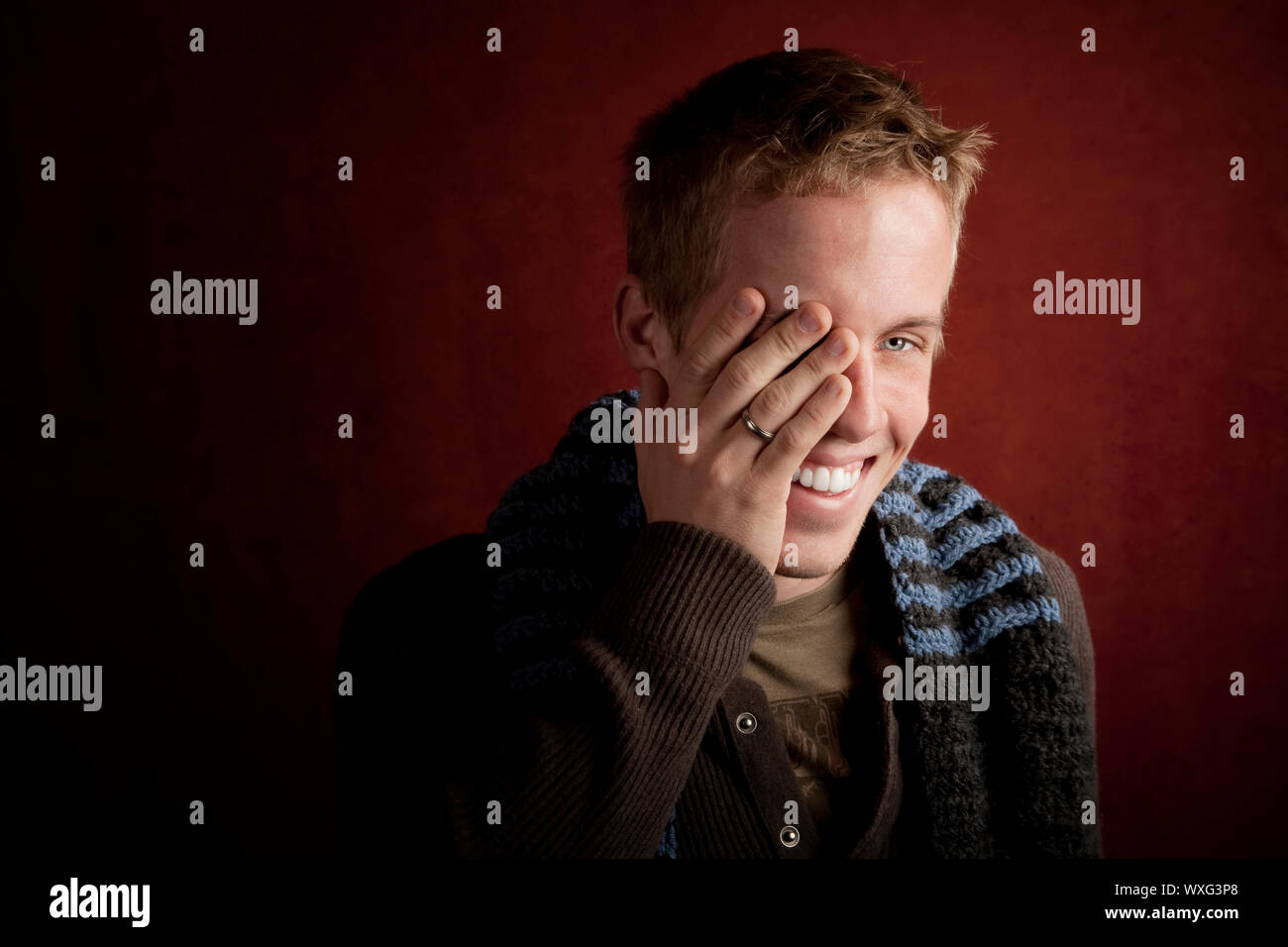 Young man covering face with his hand Stock Photo - Alamy