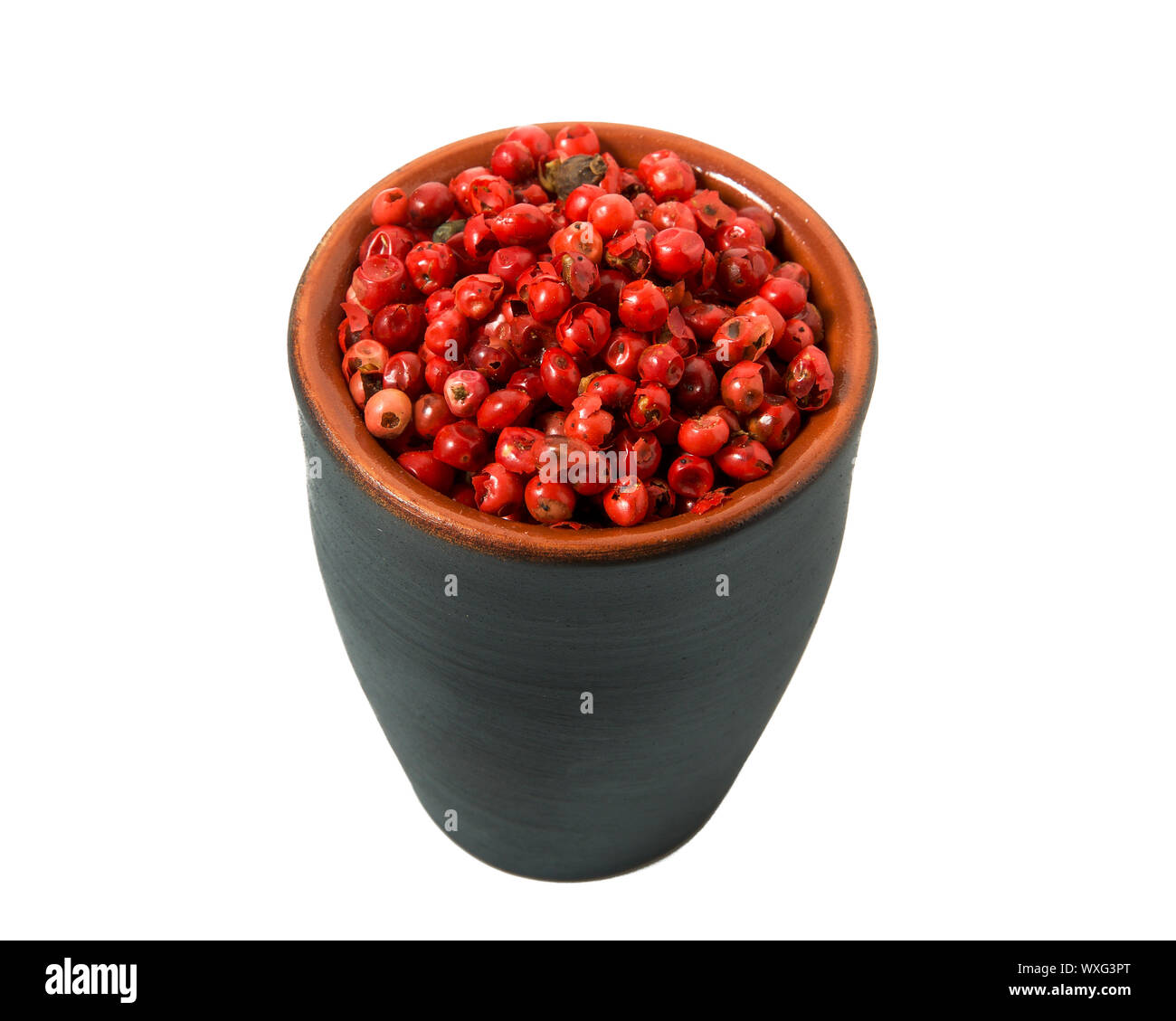 Red pepper in a bowl on isolate. View from above. Seasoning with peas of red pepper isolated on a white background. Close-up. Stock Photo