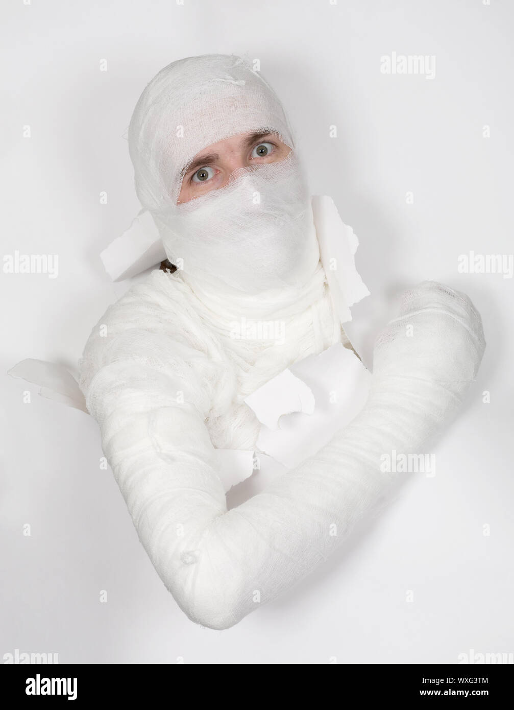 Boy in bandage put out from hole in white paper Stock Photo Alamy