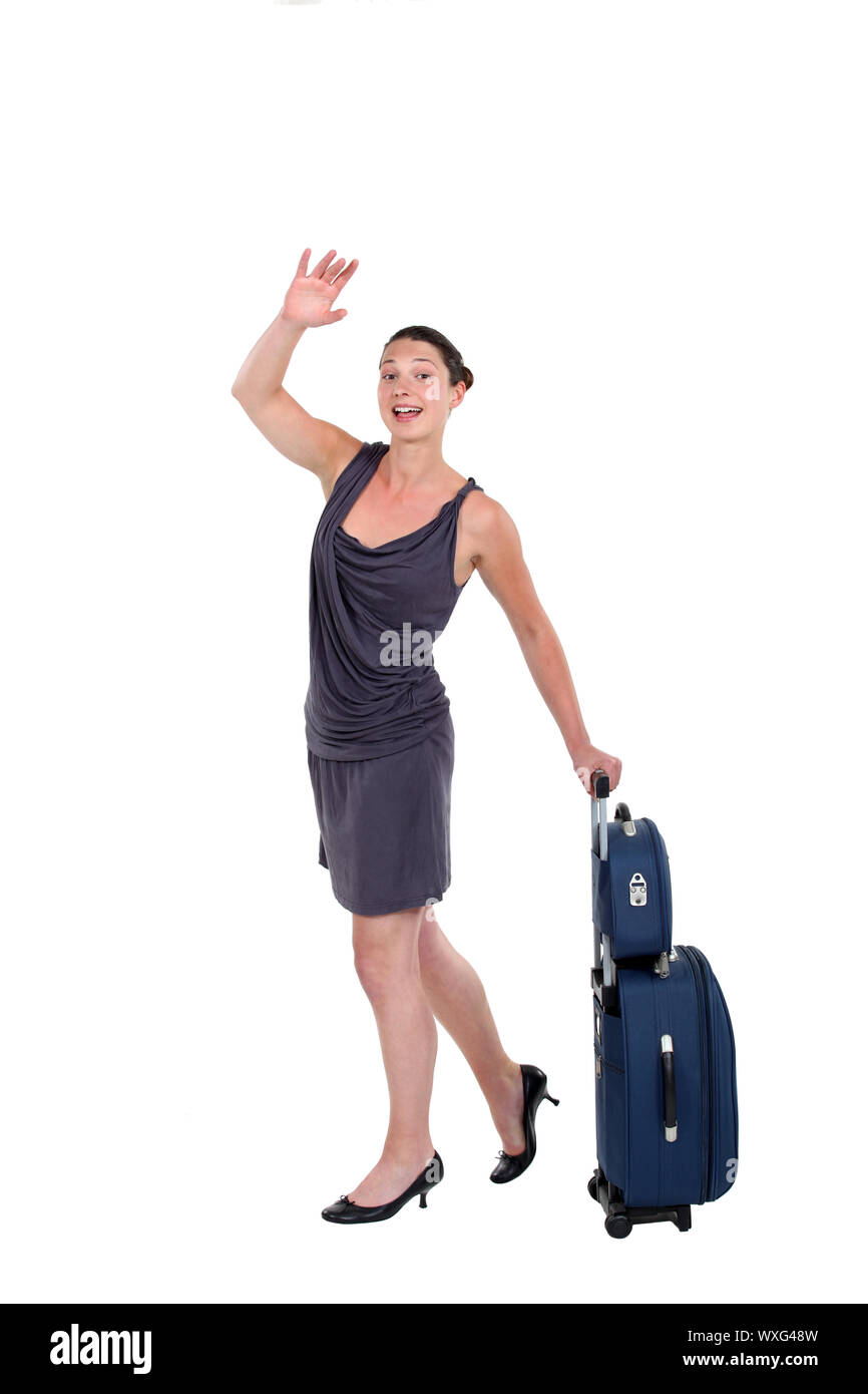 Woman with luggage hailing a taxi Stock Photo