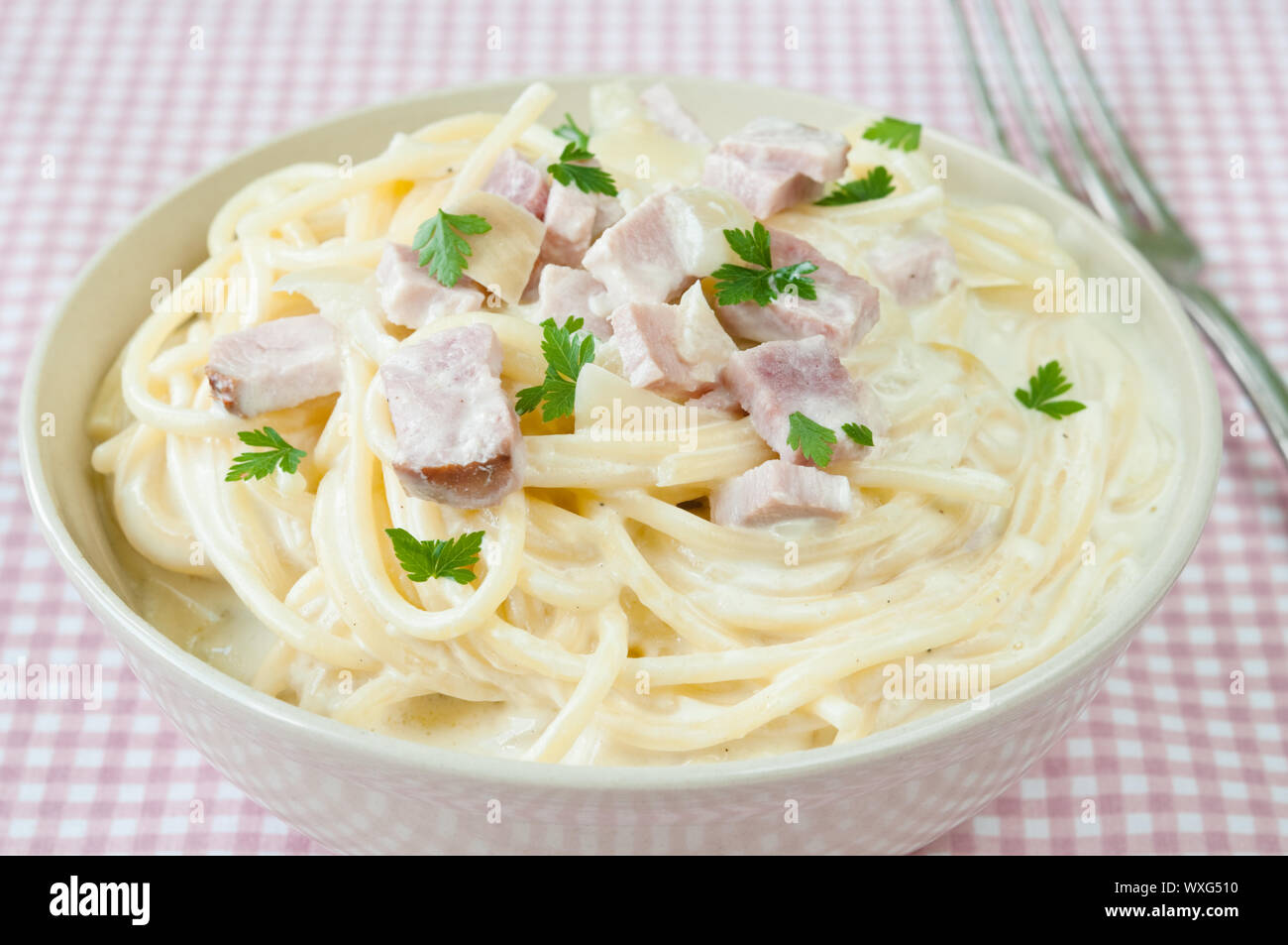 Spaghetti carbonara with ham, cheese and parsley Stock Photo - Alamy