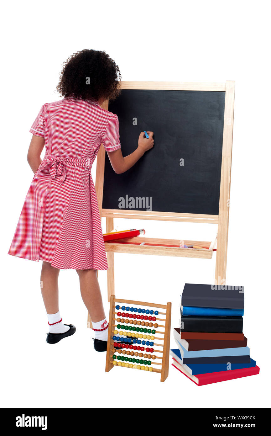 Back pose of a school girl finding solution and solving problems in maths class Stock Photo