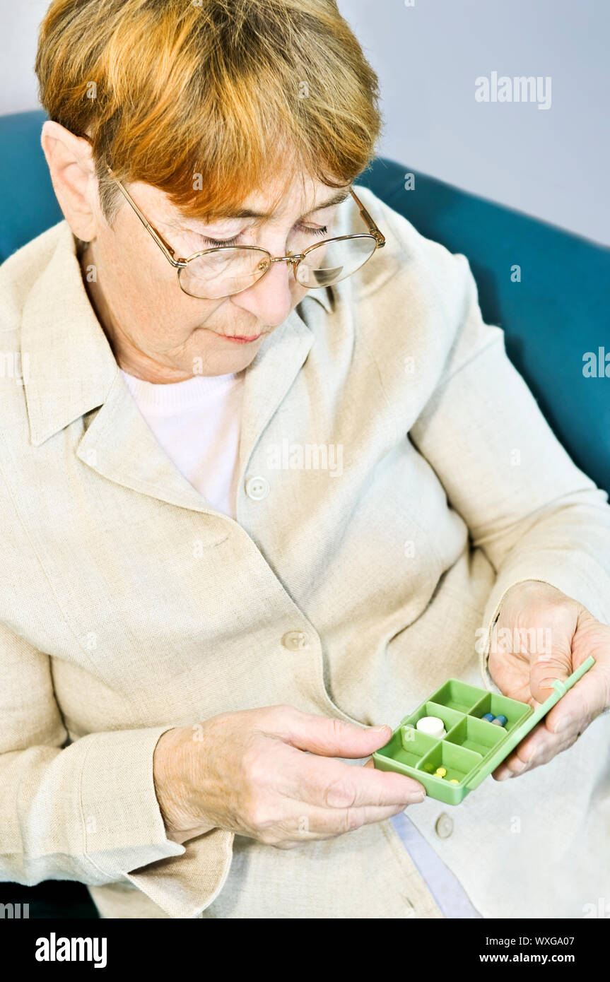 Elderly woman holding pill box with medication Stock Photo Alamy