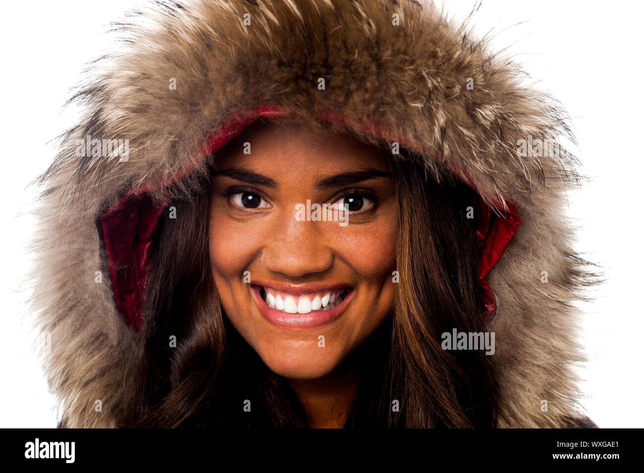 Closeup of a sweet smiling girl wearing furry hood winter jacket