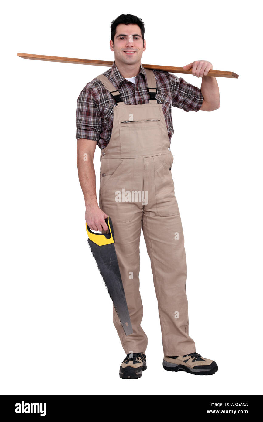 Carpenter carrying a plank of wood and a saw Stock Photo