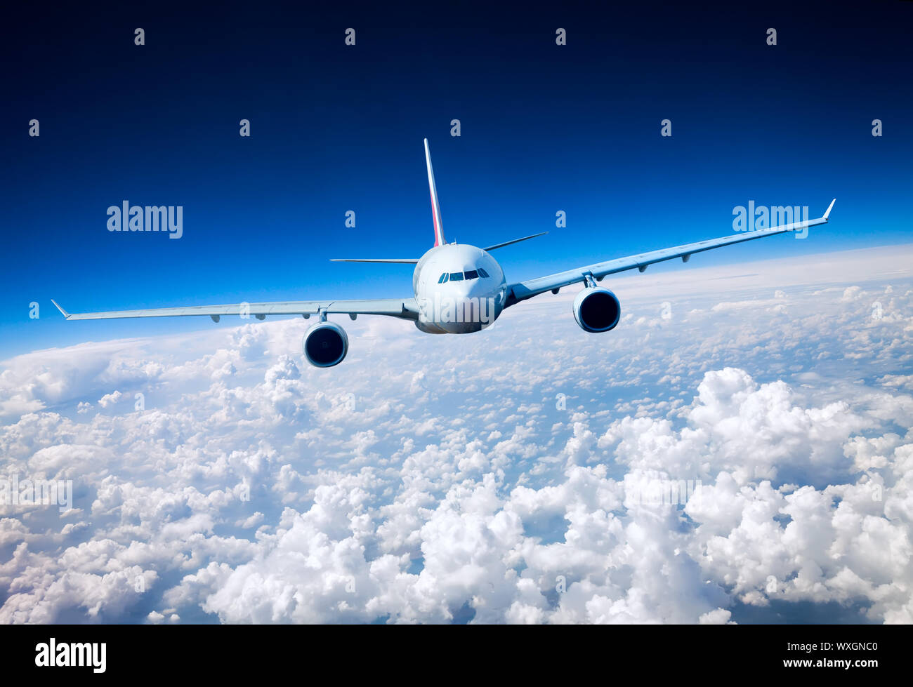 Passenger Airliner flying in the clouds Stock Photo - Alamy