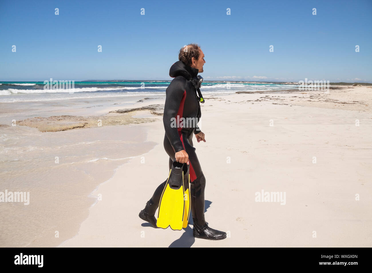 male diver with diving suit snorkel mask fins on the beach in Summer Stock Photo