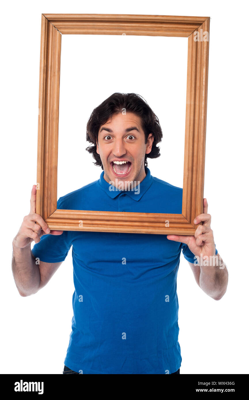 Young man holding wooden frame around his face Stock Photo Alamy