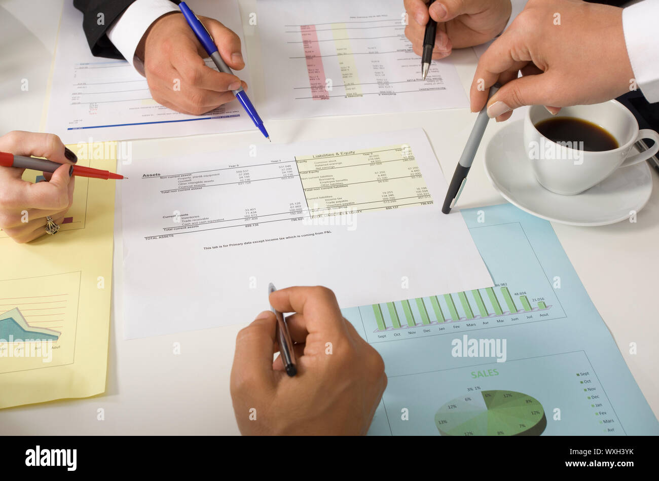 Businesspeople working together at meeting, discussing document Stock Photo