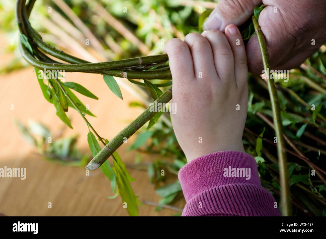 Man teaching child making a wicker basket Stock Photo - Alamy