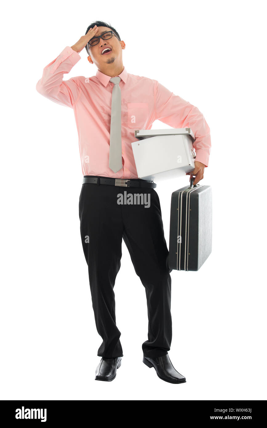 Fired Asian corporate employee holding his suitcase and belongings in a cardboard box, Isolated on white background. Stock Photo