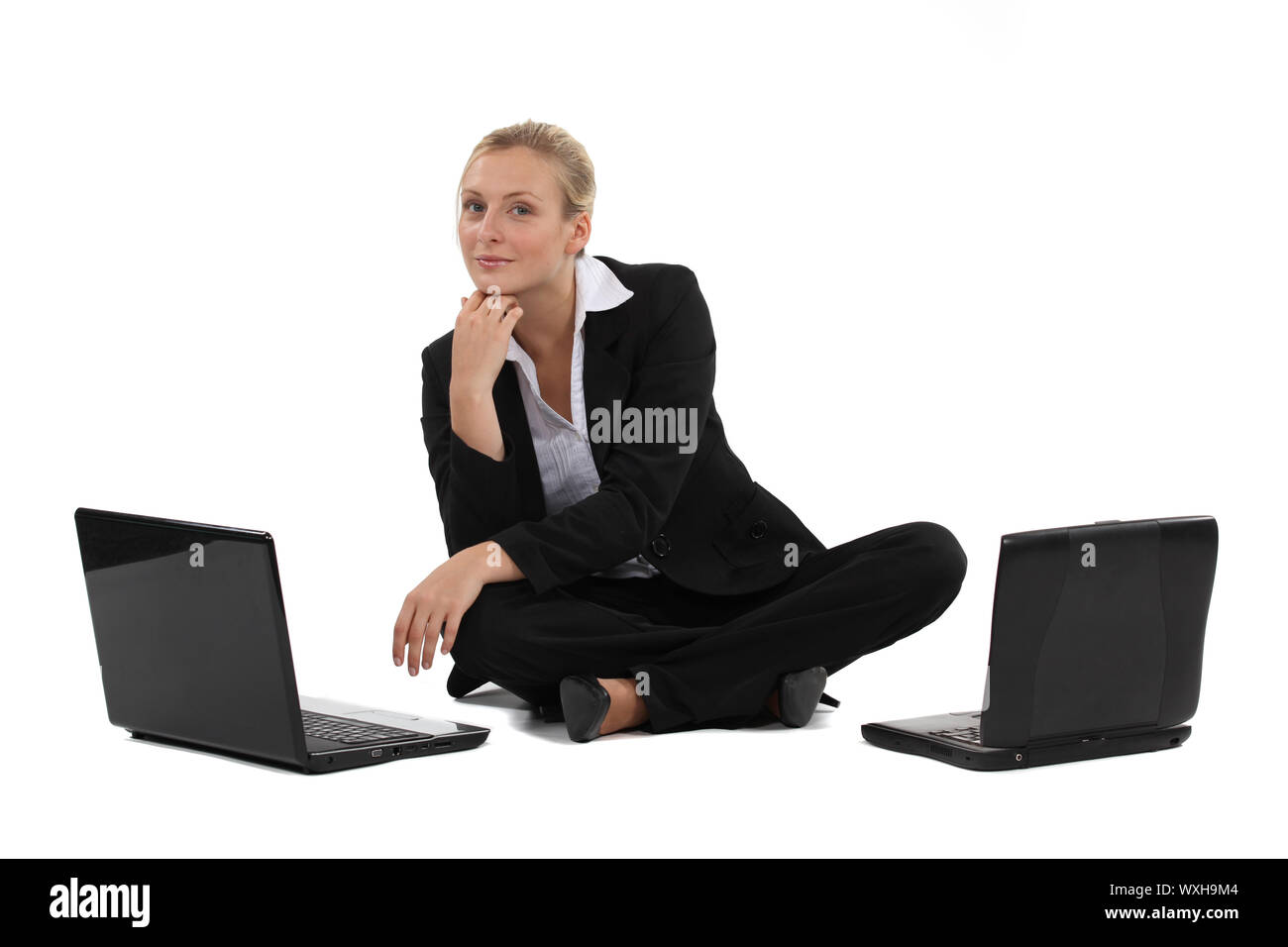 Blond businesswoman sat on the floor with two laptops Stock Photo - Alamy