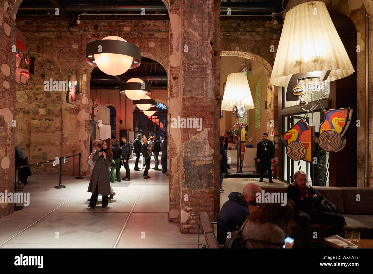 TURIN, ITALY - NOVEMBER 3, 2018: Ogr, Officine Grandi Riparazioni cafe interior with people, evening in Turin, Italy. Stock Photo