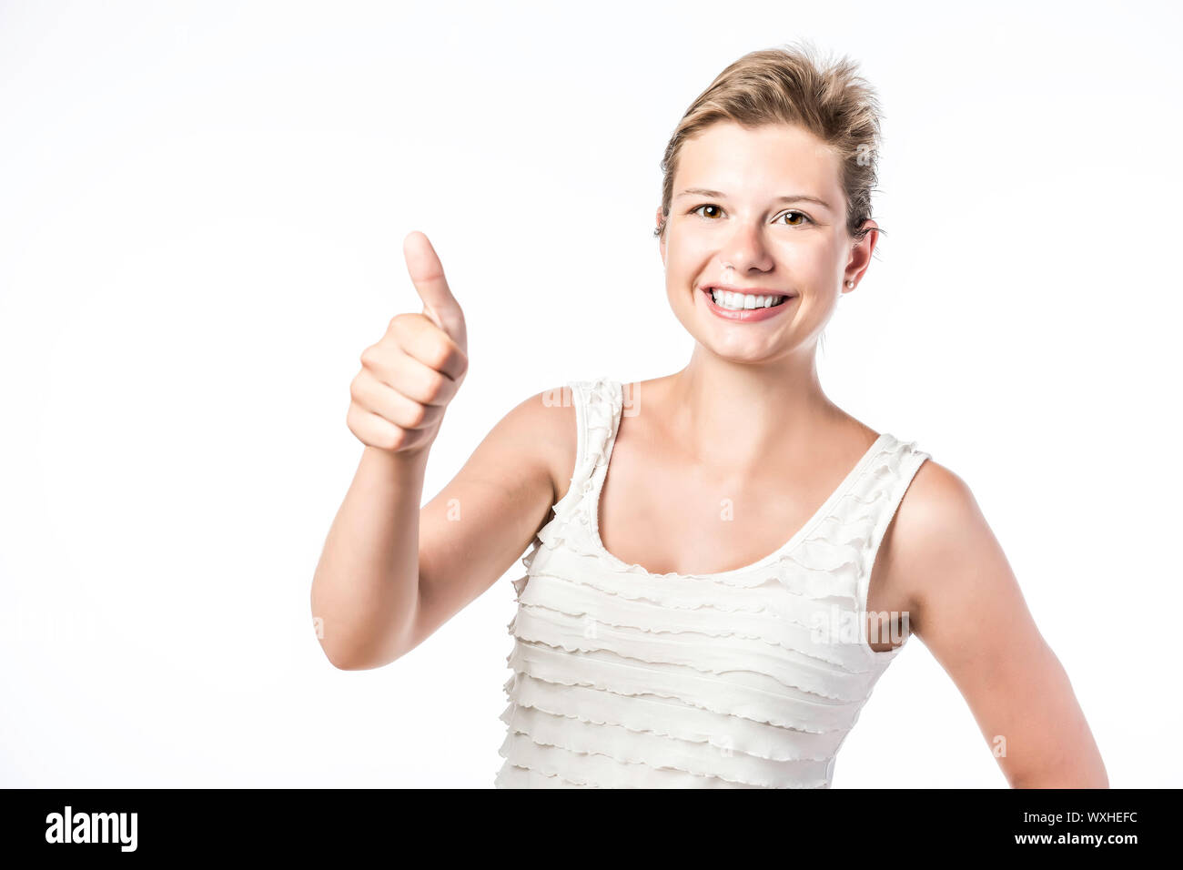 Laughing, young beautiful woman holds her thumb up, isolated on white background Stock Photo