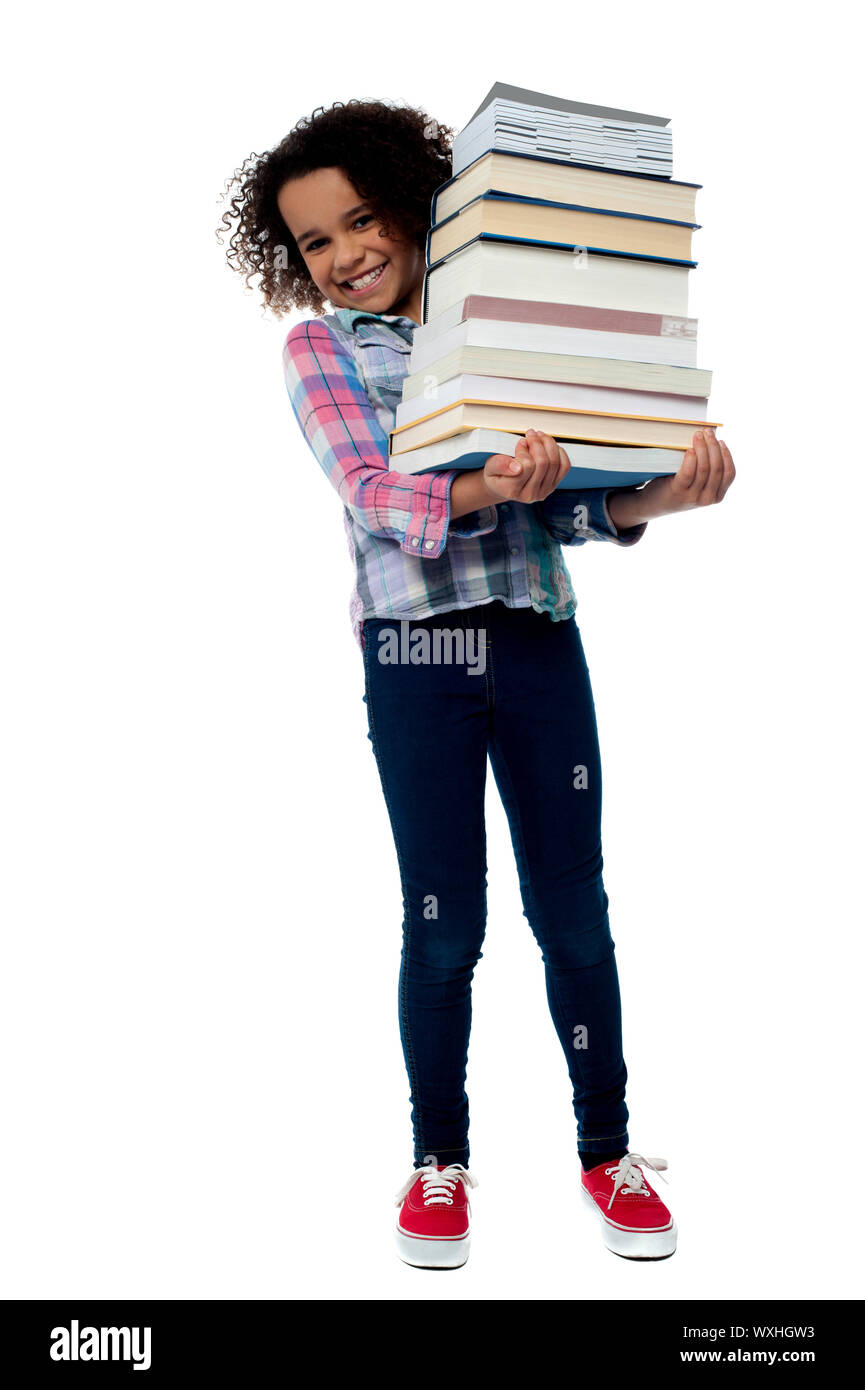 Smiling little girl holding stack of school books Stock Photo - Alamy
