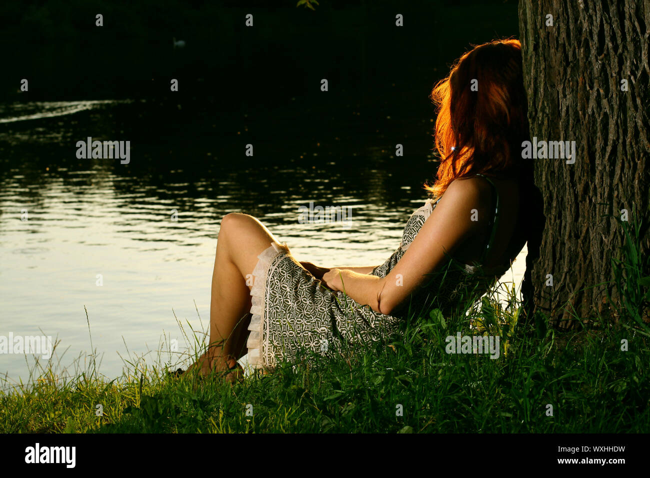 Girl sitting on tha bank of forest river Stock Photo - Alamy