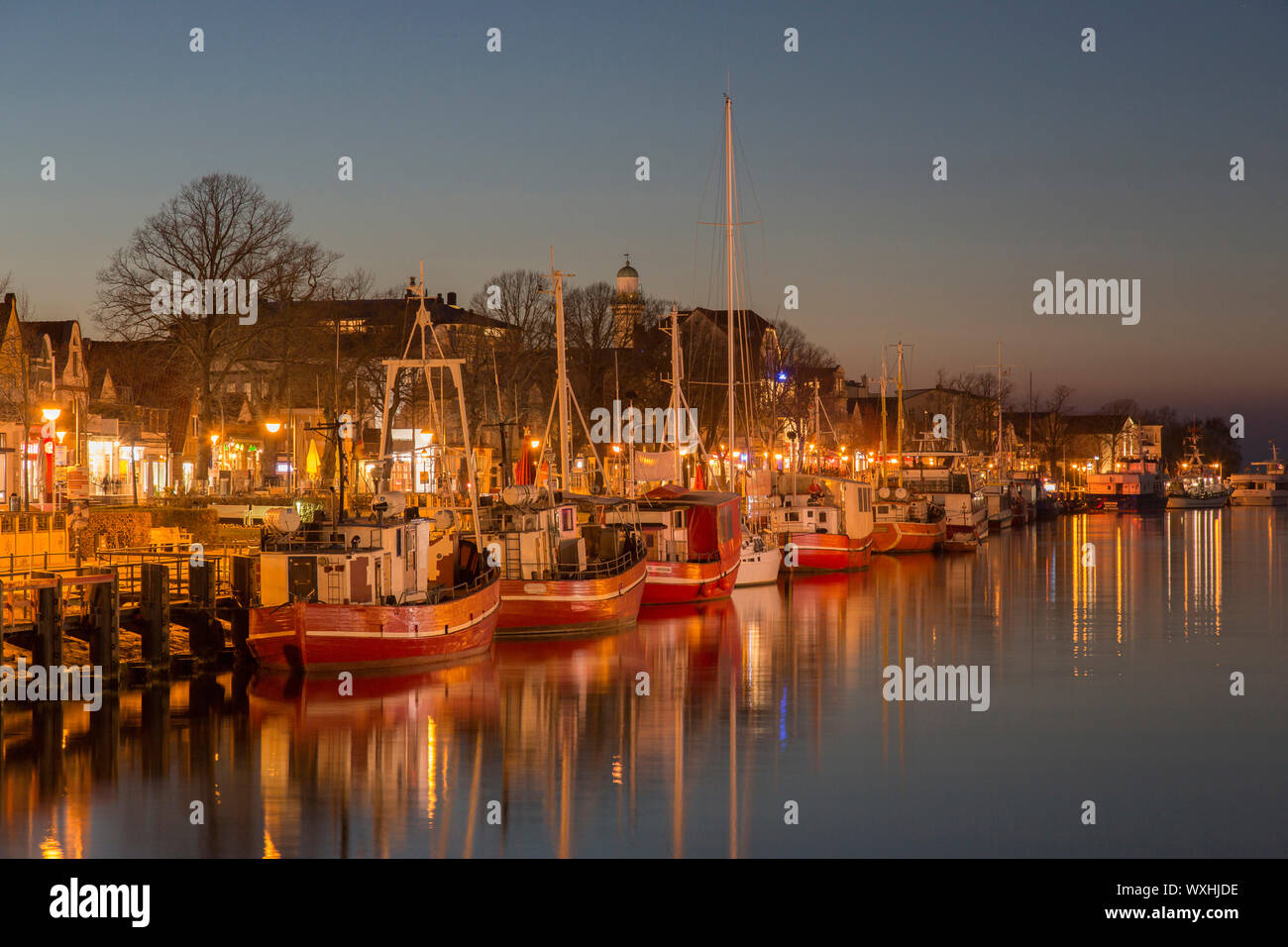 Traditional fishing boats on the canal called der Alte Strom (Old Channel) at night. Warnemuende