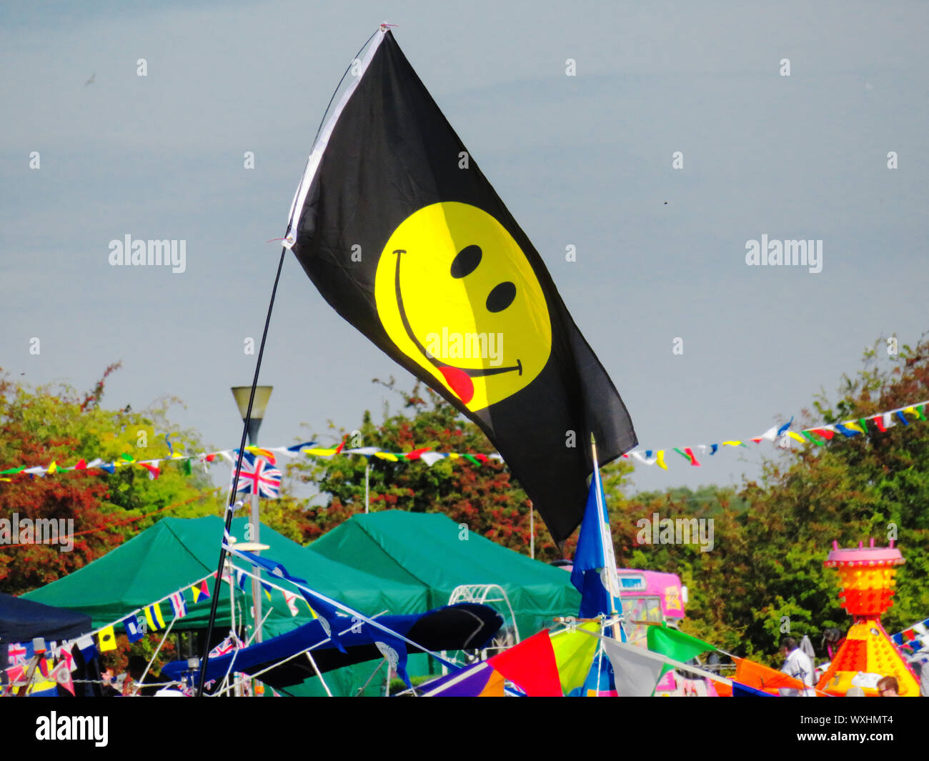 Yellow Smiling Face emoji on a black flag Stock Photo
