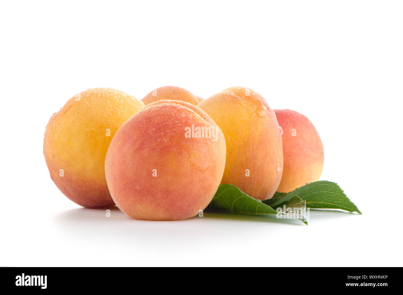 Sweet peaches with leafs on a white background Stock Photo