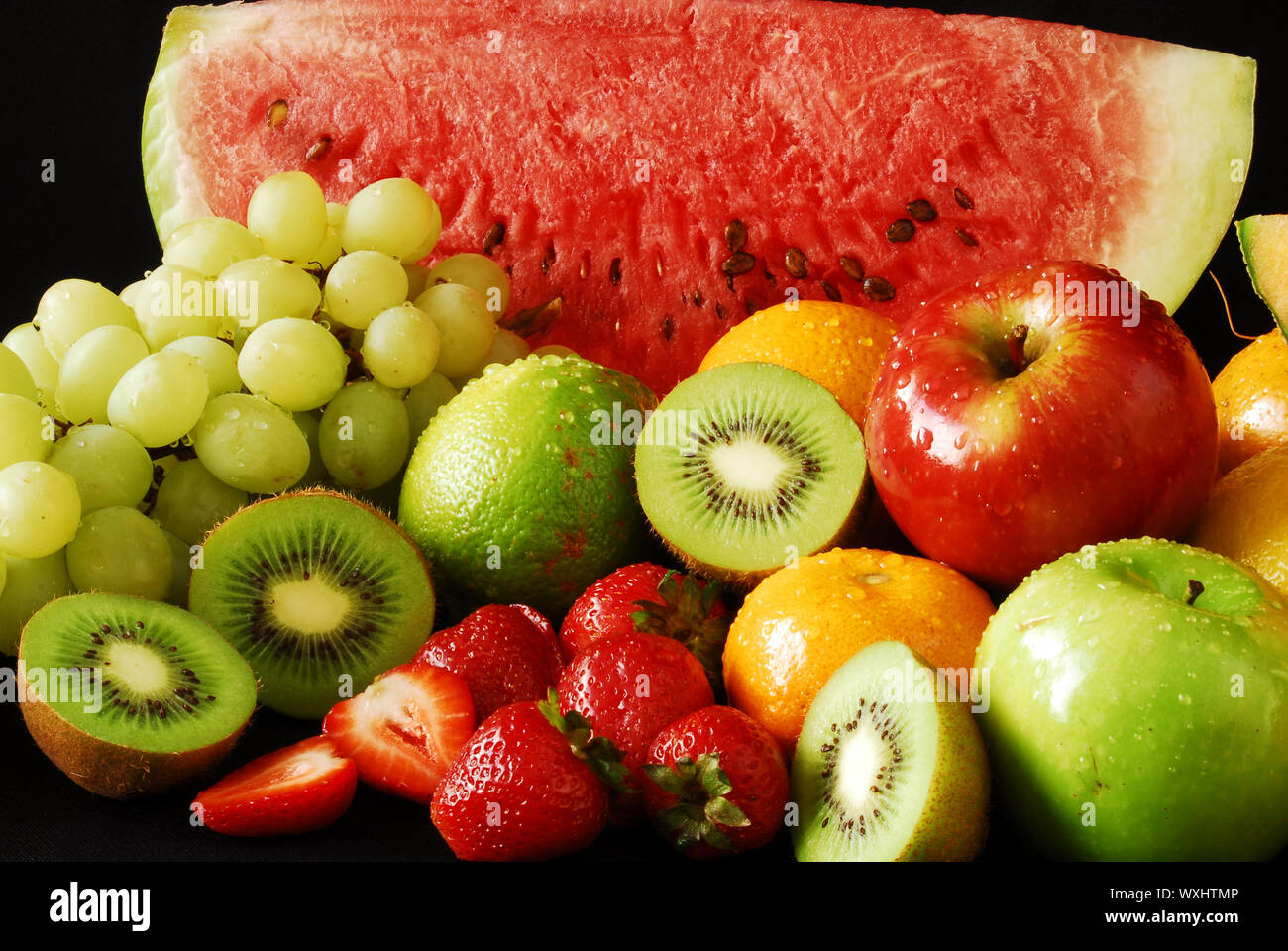 Colorful fresh group of fruits for a balanced diet. Black background ...