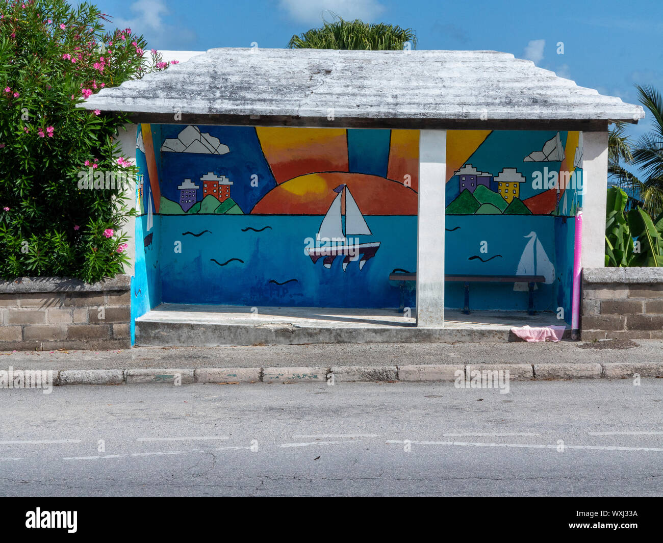 A brightly painted bus shelter on the roadside in Bermuda Stock Photo