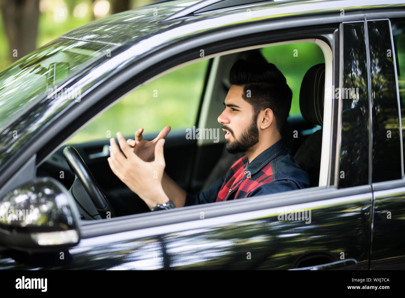 Young man driving a car and looks angry and screaming Stock Photo
