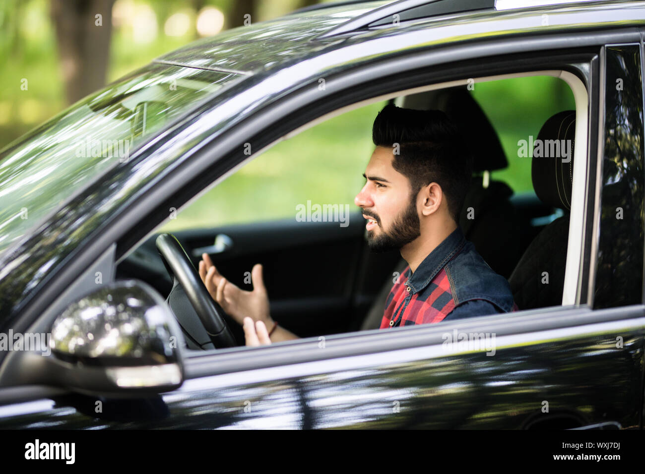 Young man driving a car and looks angry and screaming Stock Photo