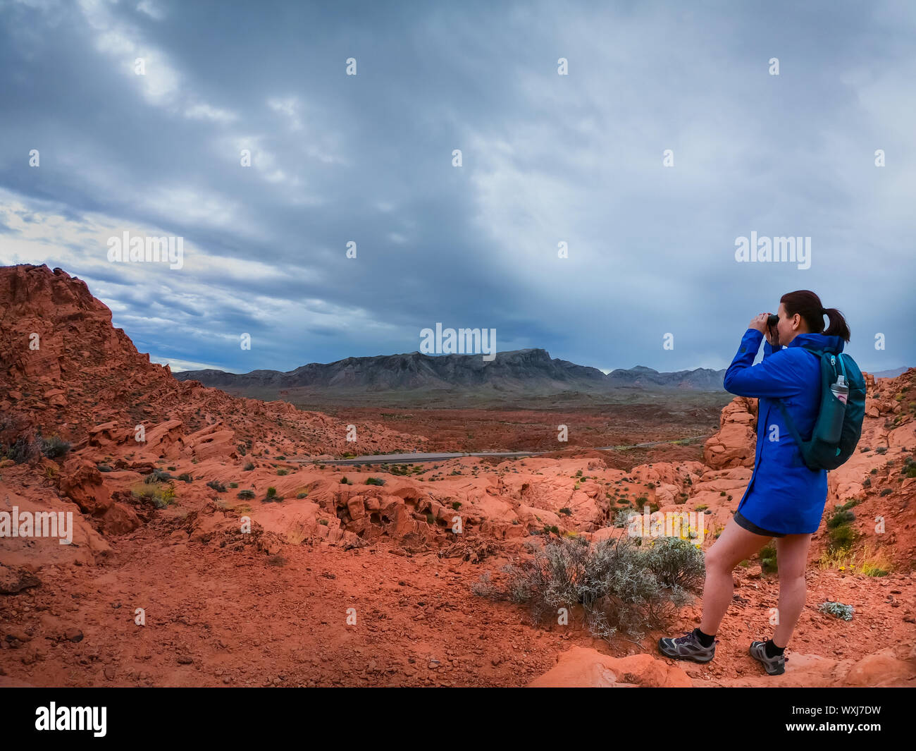 Female hiker looking through binoculars, Utah, United States Stock Photo