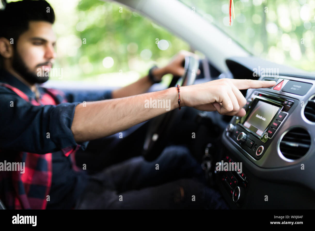 transportation and vehicle concept - man pressing red triangle car hazard warning button Stock Photo