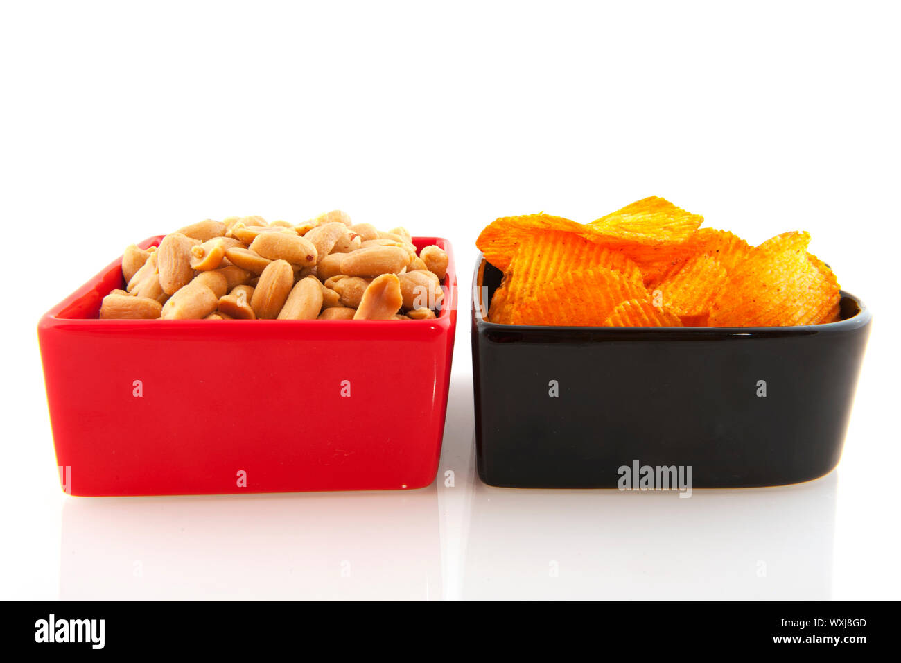 Peanuts and potato chips in red and black bowls Stock Photo Alamy