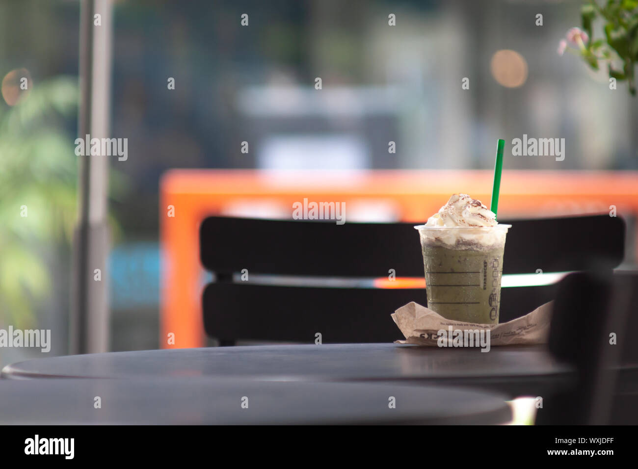 Bangkok, Thailand - Sep 1, 2019: a grande size cup of Starbuck coffee on the outdoor table. Starbucks take away green tea frappuccino cup with logo, b Stock Photo
