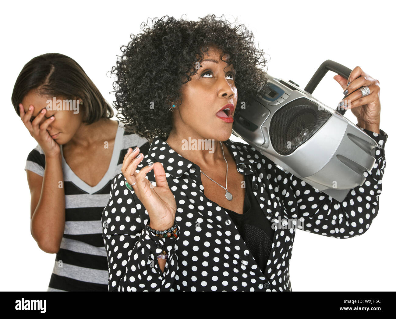 Teen with hand on face near singing parent and radio Stock Photo
