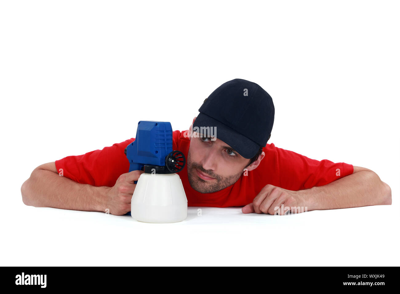 A painter examining his spray gun. Stock Photo