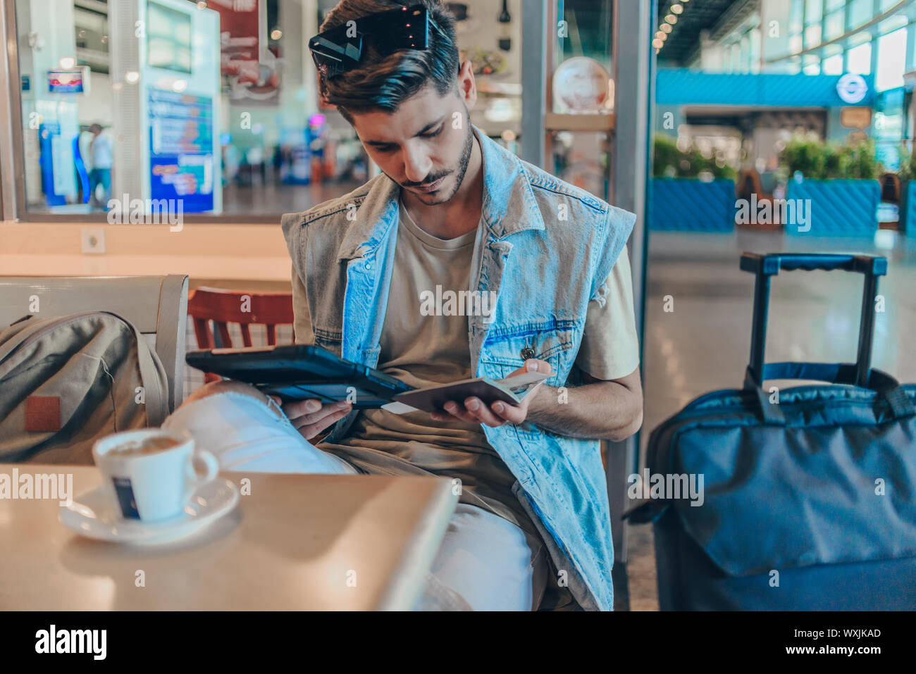 Passenger using digital tablet in airport departure lounge Stock Photo Alamy