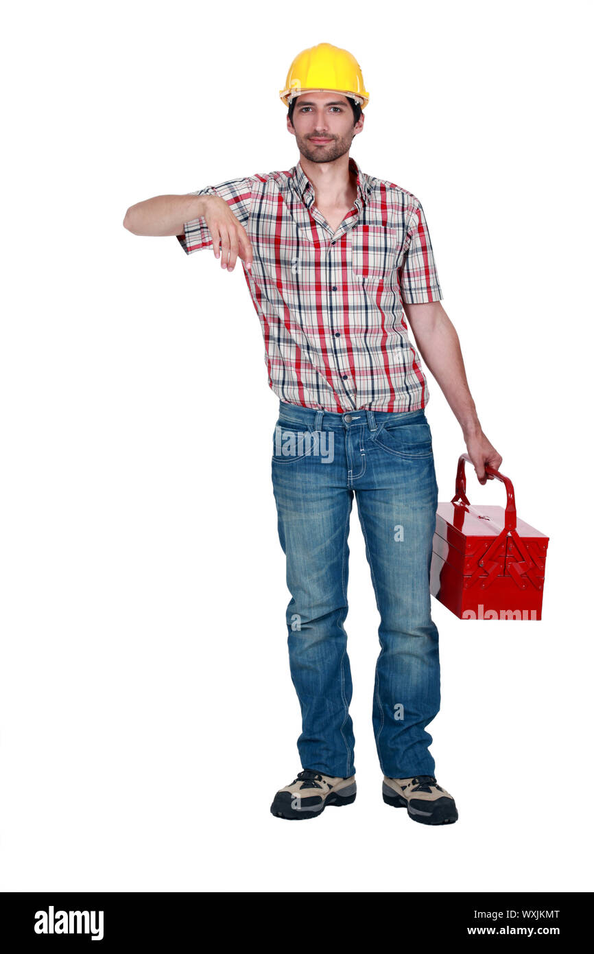 A construction worker carrying a toolbox. Stock Photo