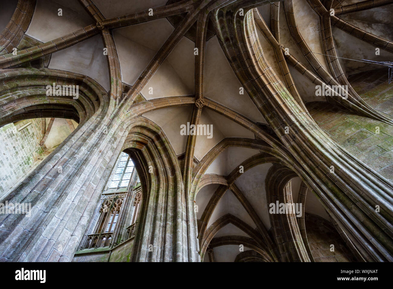 Stone arches within Mont Saint-Michel abbey / cathedral with a wide angle lens, Normandy, France Stock Photo