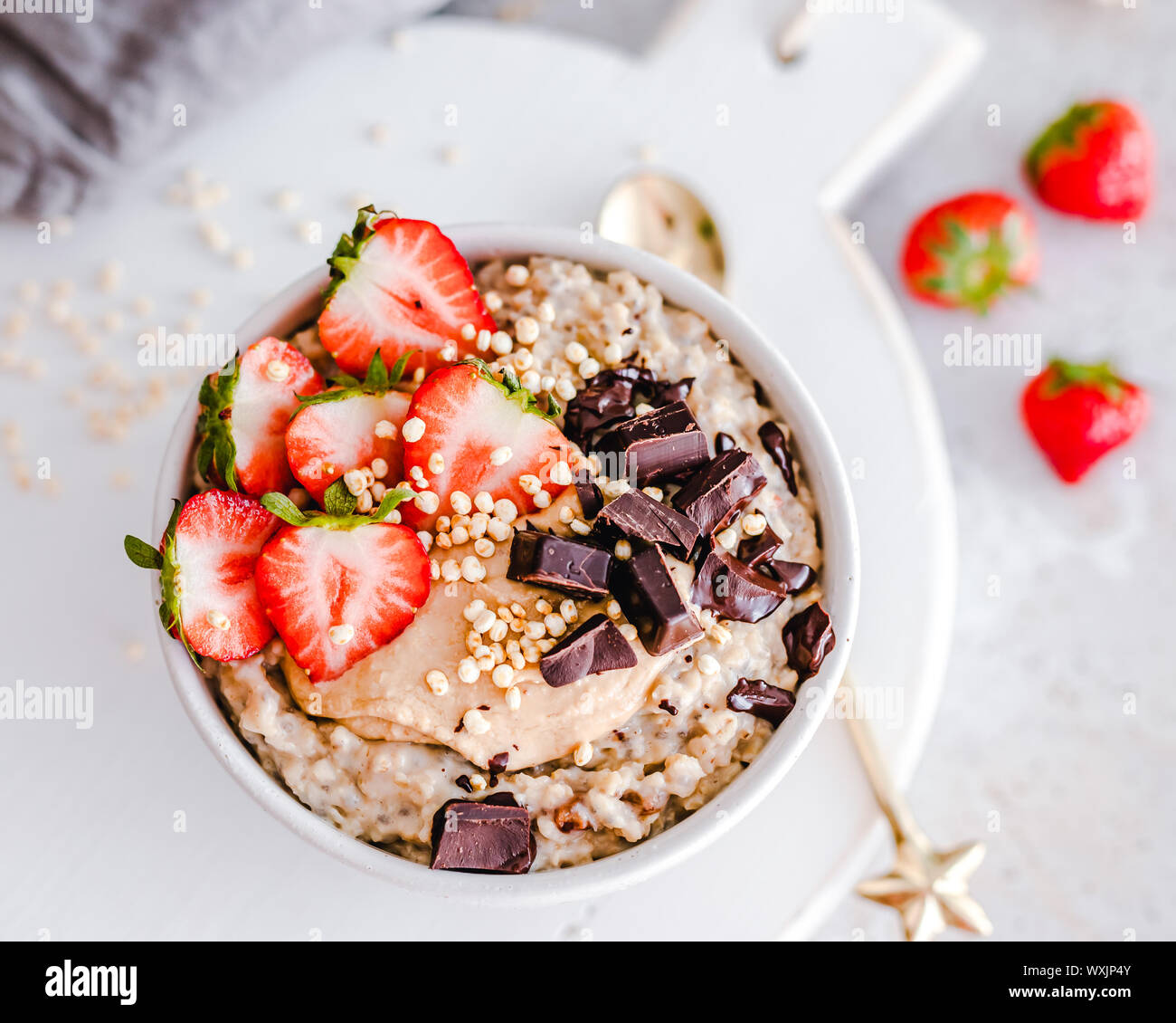 Oatmeal bowl with strawberries, peanut butter, chocolate and puffed rice Stock Photo