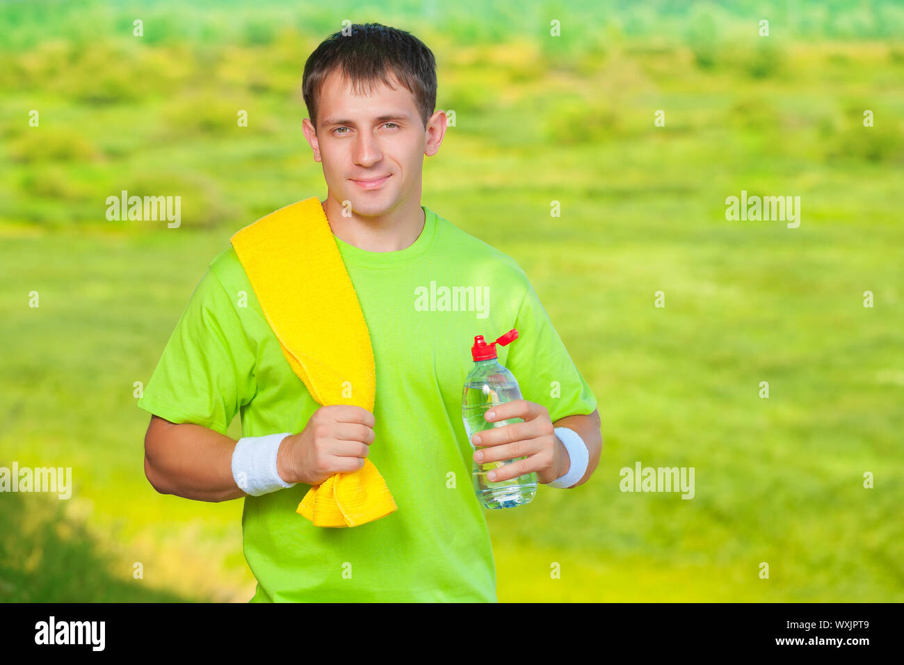 a sports man with towel holding bottle of water Stock Photo - Alamy