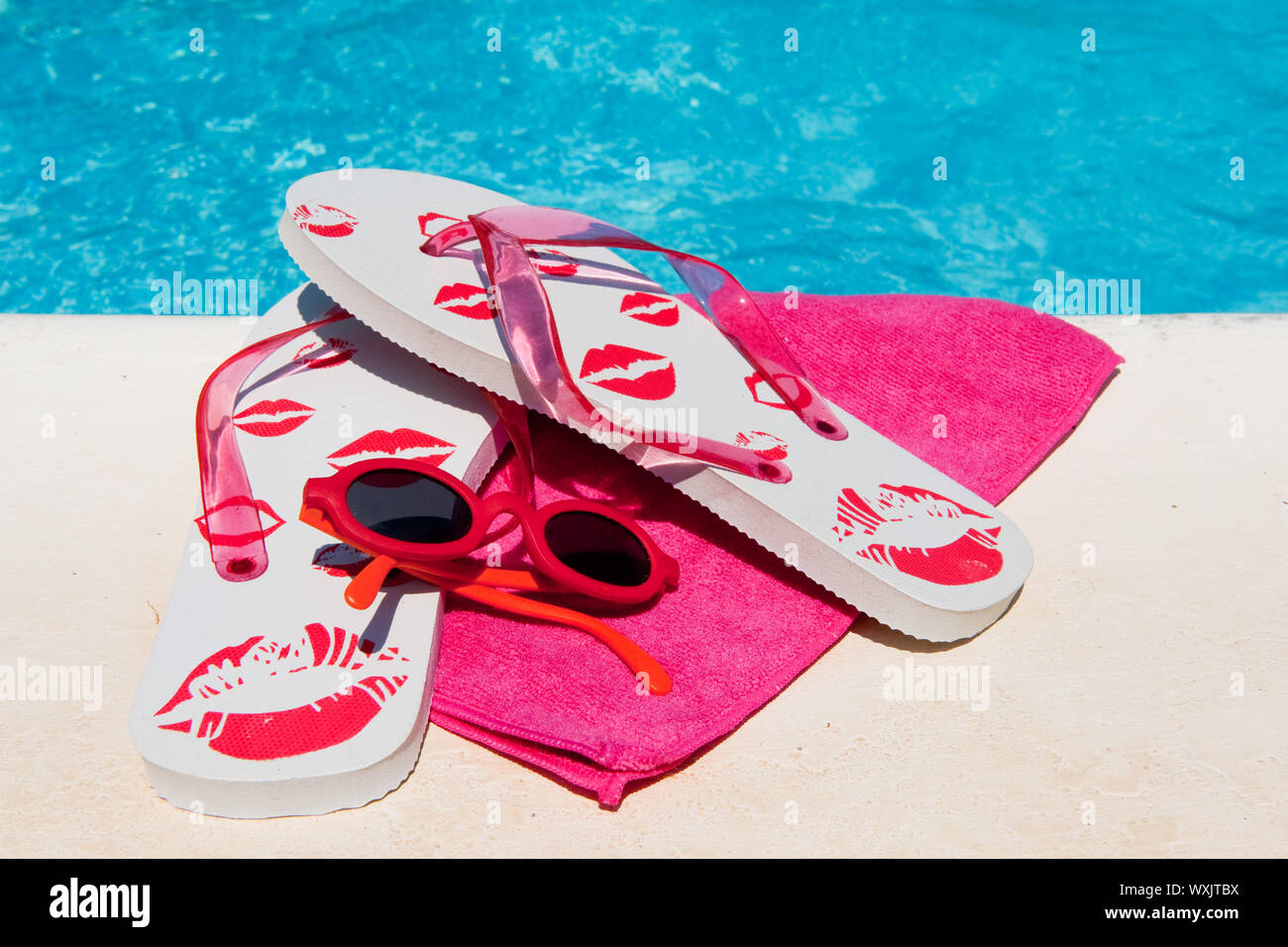 Flip flops near the swimming pool with blue water Stock Photo - Alamy