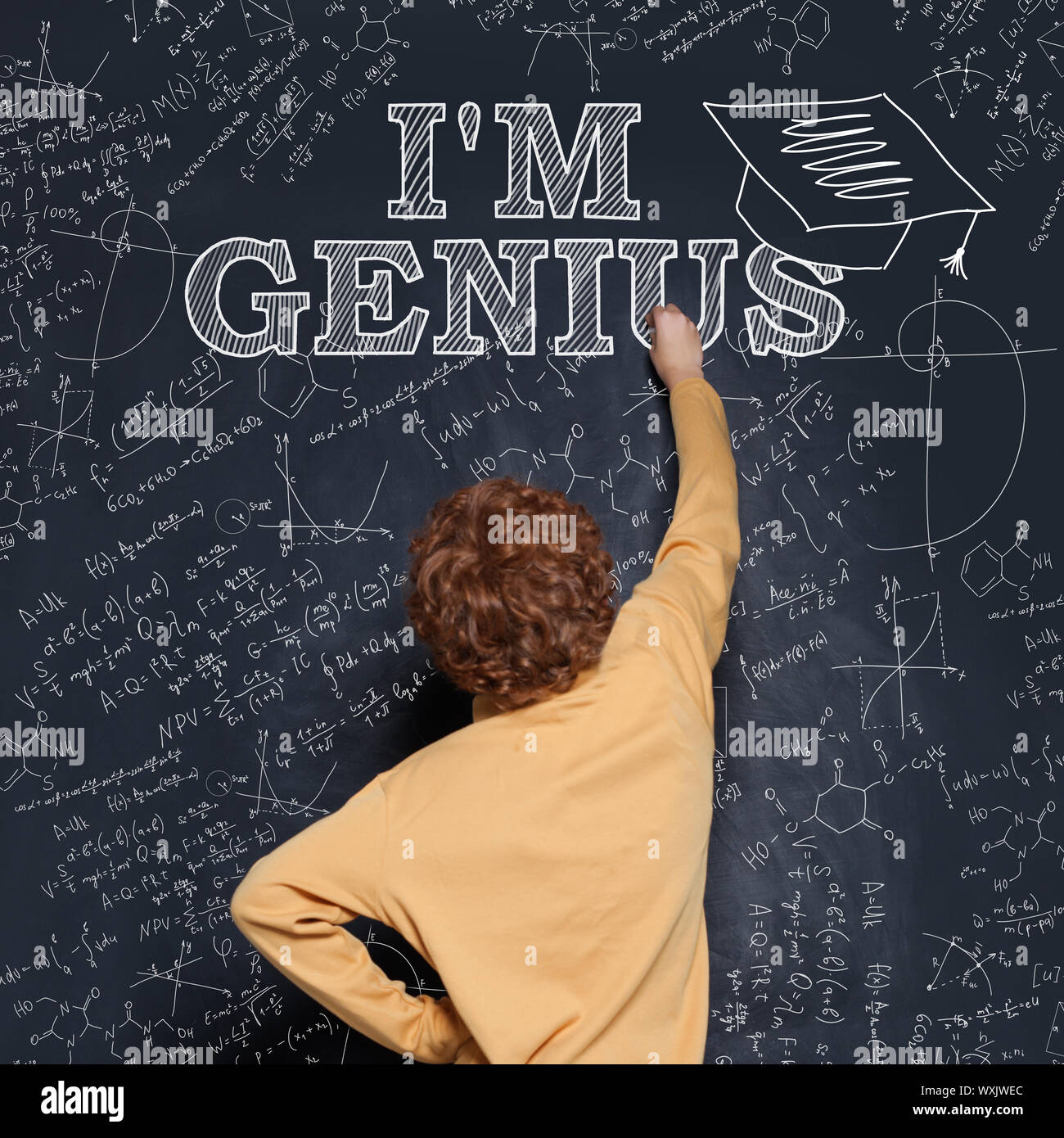 Prodigy child boy writing on blackboard Genius inscription. Early development concept Stock Photo