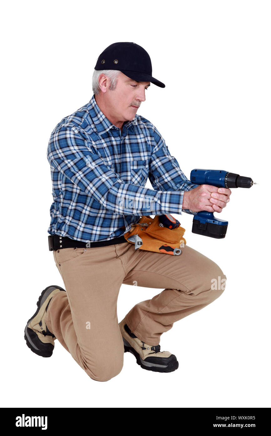 Grey haired man with drill Stock Photo