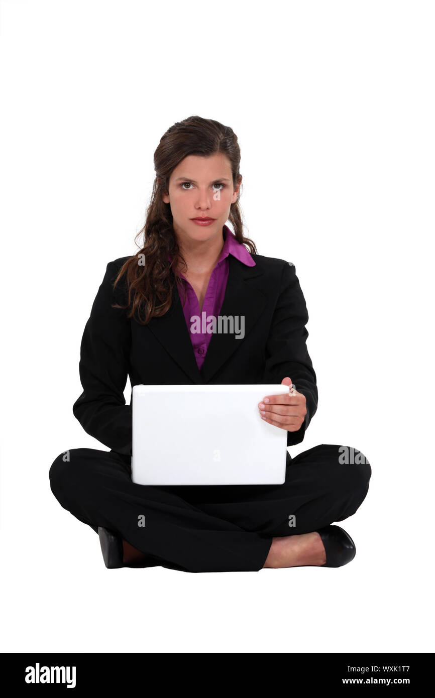 Brunette businesswoman sat cross-legged on the floor Stock Photo