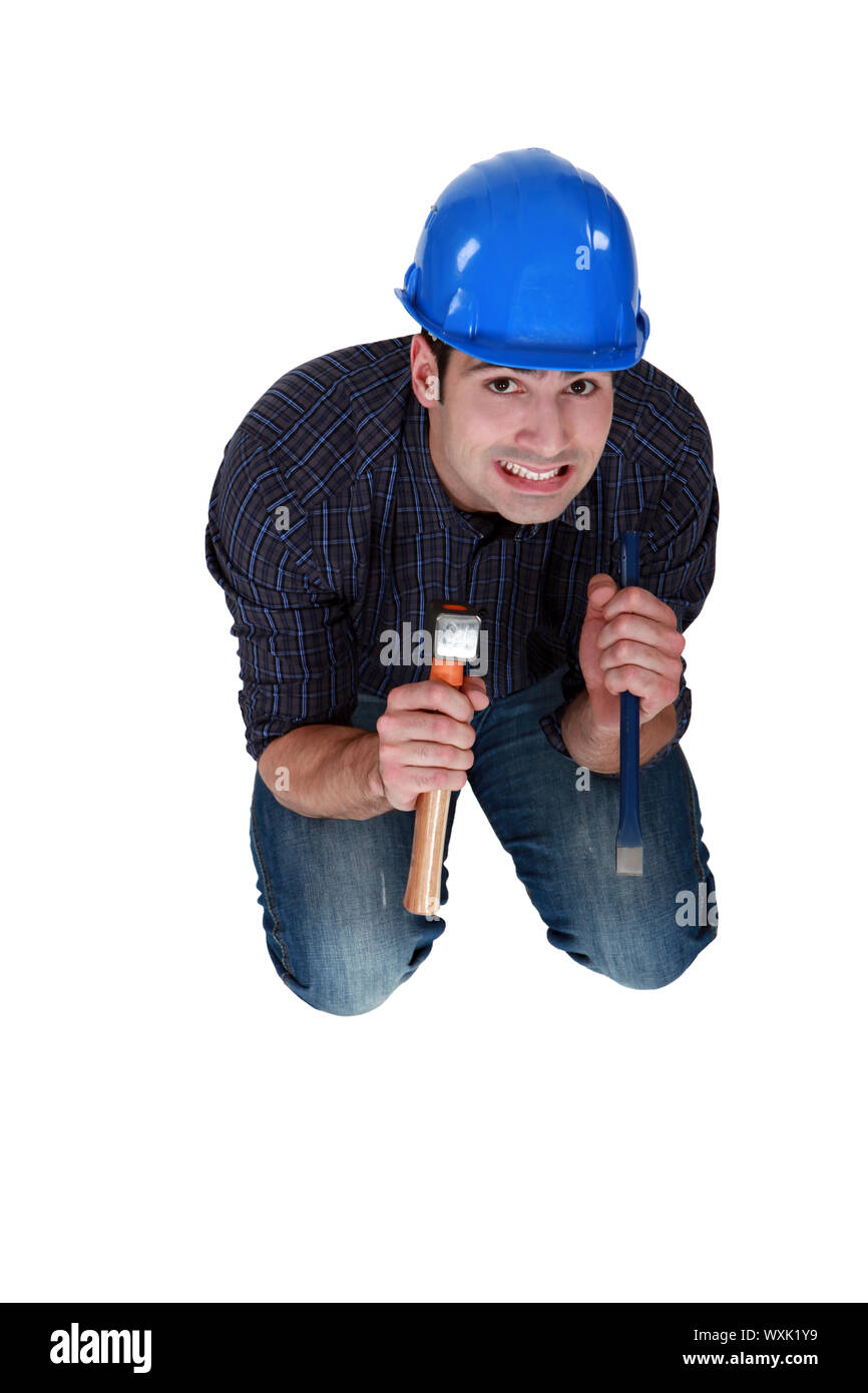Nervous woodworker holding hammer and chisel Stock Photo